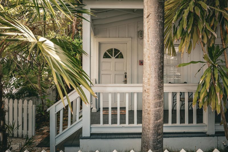 Home 16 Charming tropical front porch with palm trees and white wood 1772557439