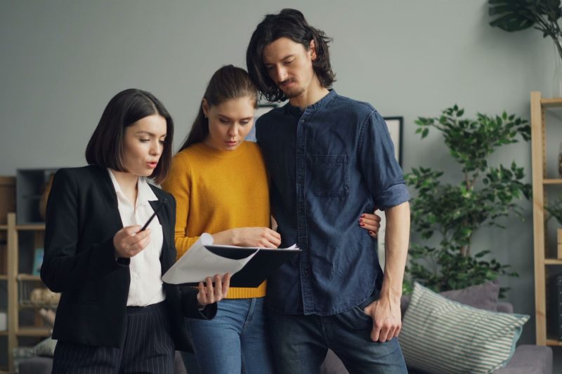 Home 26 A couple reviewing documents with a real estate agent indoor 1781629493