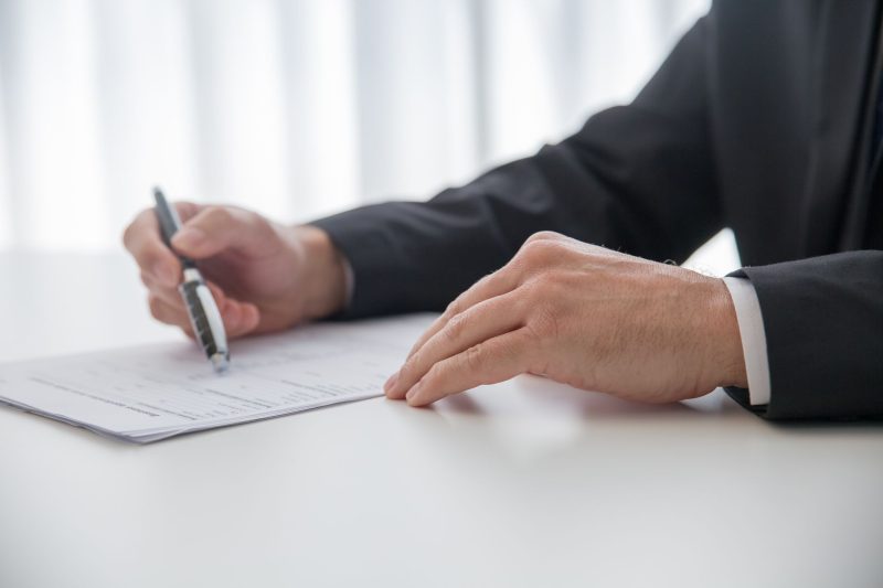 Home 20 Businessman signing important documents at office desk 1785258602
