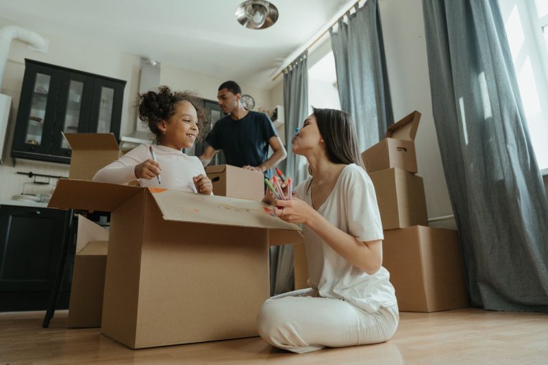 Home 20 A joyful family unpacking boxes while moving into their new 1793120483